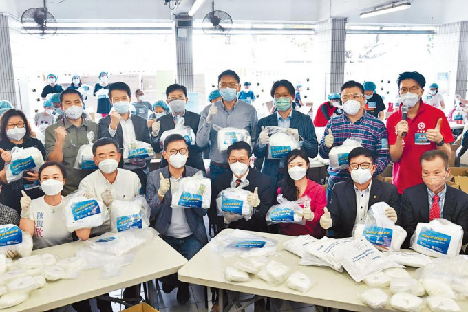 署理民政事务局局长陈积志（前排左四）联同四名立法会议员，参与包装防疫服务包。
