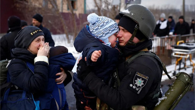 烏克蘭小男童與父親難分難捨。路透社圖