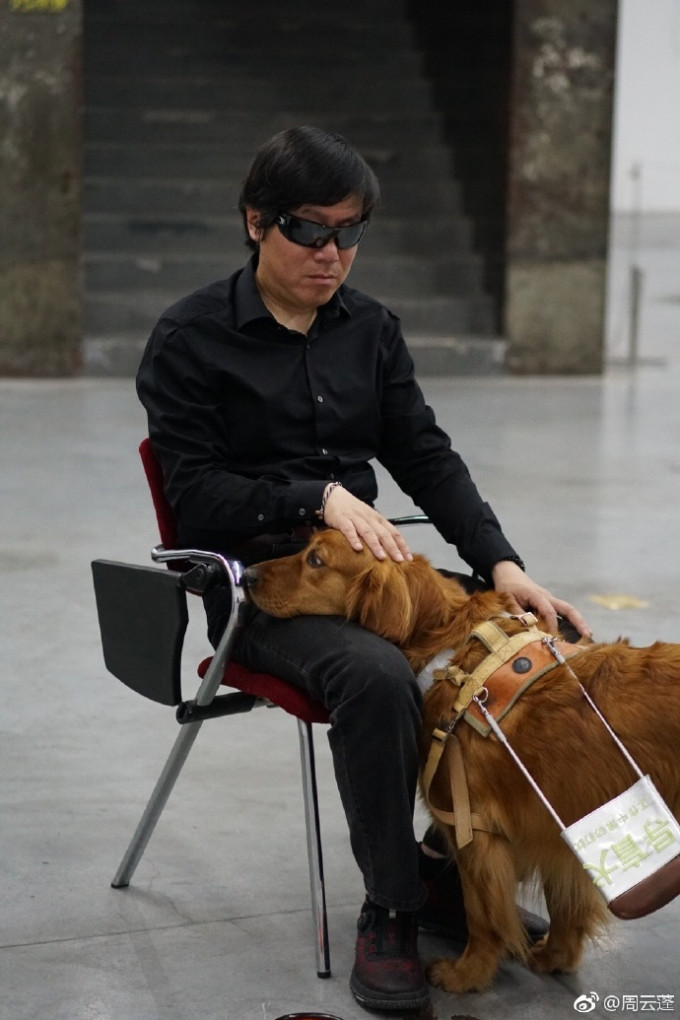 內地盲人歌手周雲蓬及其導盲犬「熊熊」。 網圖