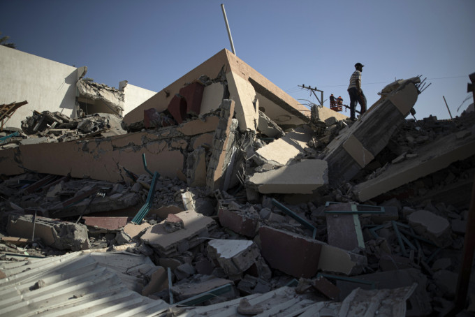 一幢据称是巴勒斯坦激进组织哈马斯的办公室大楼遭以军空袭击垮倒塌。AP图片