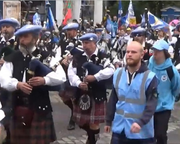 示威抗议者高举苏格兰旗帜穿上苏格兰短褶裙吹奏包括风笛等乐器。网图