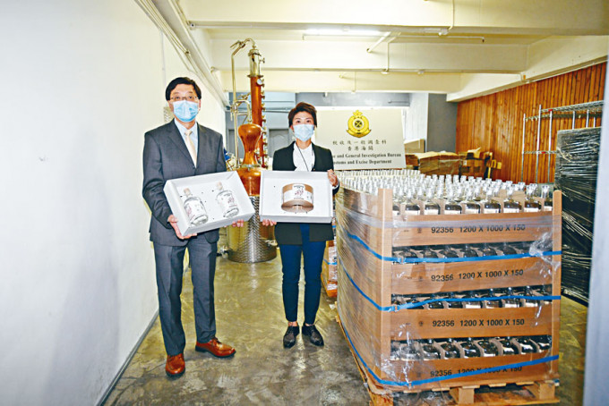 ■海关黄惜忻（右）与马祖光，展示搜出的冒充港产毡酒。