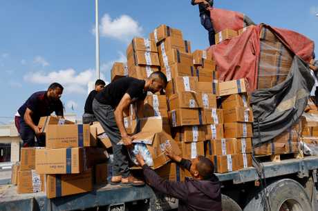 在加沙南部拉法口岸，巴人將從載送援助物資卡車掉落的物資重新裝載上車。路透社