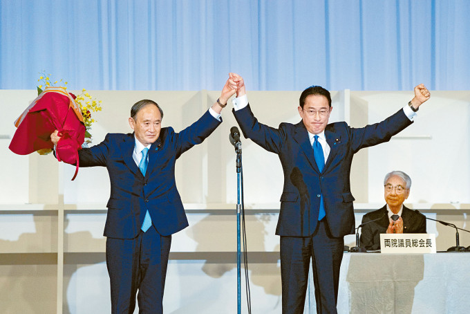 岸田文雄（右）在周三自民党总裁选举获确认胜出后，与现任首相菅义伟携手庆祝。