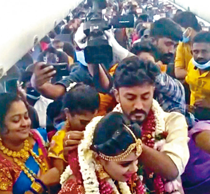 網上片段可見印度一對新人和賓客擠在客機上。