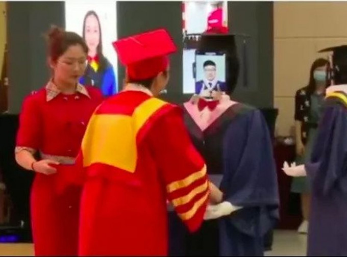 南京邮电大学借助机械人，帮助部分毕业生接受证书。网图
