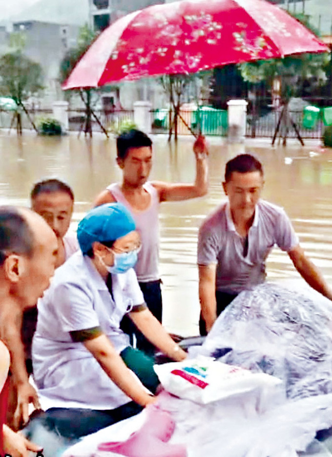 ■医生和居民在洪水中守护着临盆的孕妇。