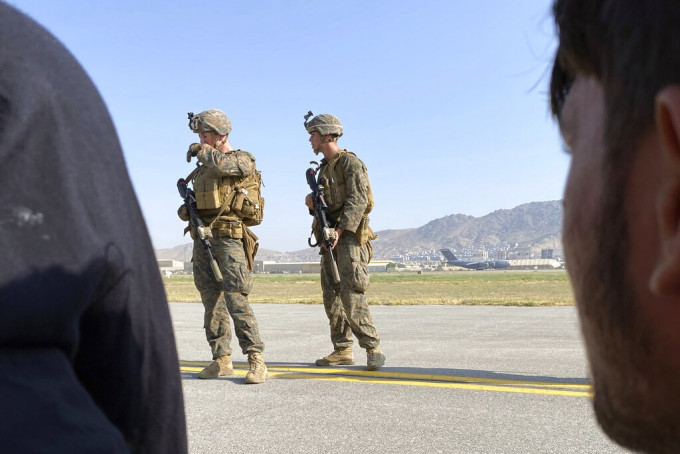 美军驱散阻碍飞机撤离的阿富汗民众。AP图片