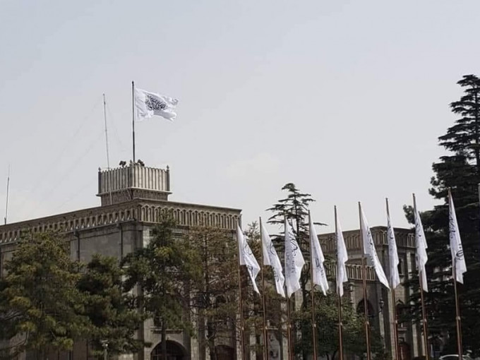 喀布爾的總統府升起塔利班旗幟。網圖