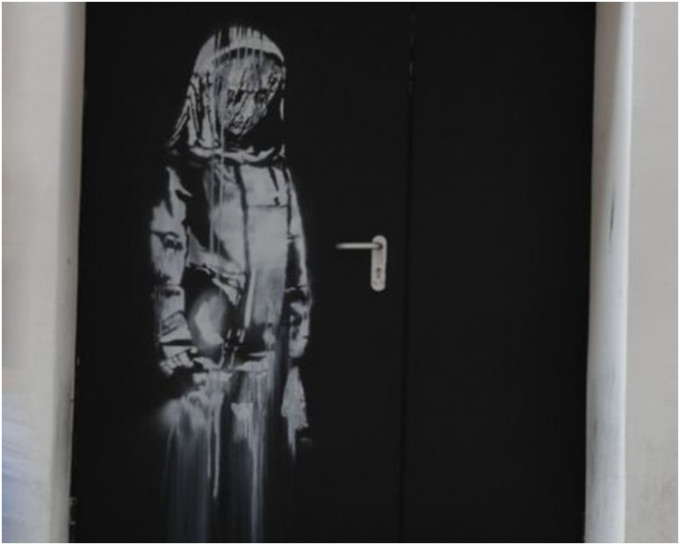 這副劇院逃生門上繪製少女低頭哀悼的畫像日前被人偷走。網圖