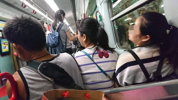 东铁线有乘客硬要摄入两乘客中间，企图迫走靠近通道的大叔。网民Chui Ho Yue/ fb群组巴打丝打 Facebook Club