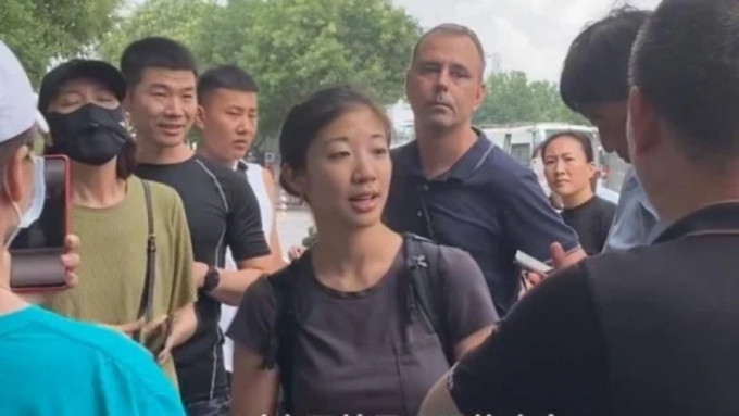 一名外媒记者与陪同人员一起在郑州采访水灾，遭到几名郑州市民的抗议和阻拦。网图