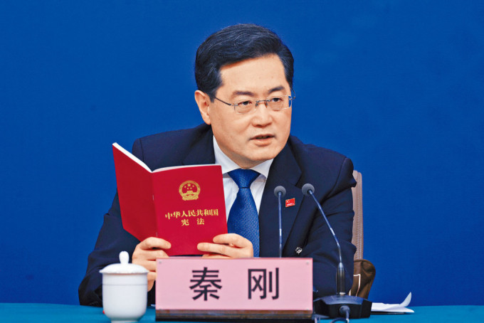谈到台湾问题时，外交部长秦刚拿起一本《中华人民共和国宪法》。