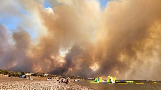 希腊罗德岛山火肆虐，游客沙滩等待救援。美联社