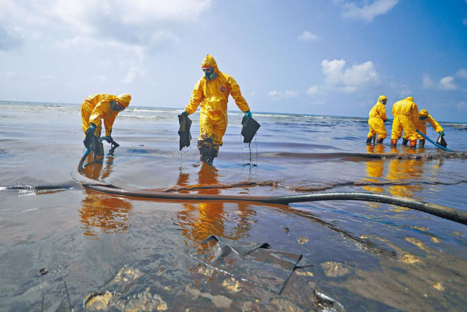 工作人员在泰国东岸的湄蓝篷海滩，清理油污。