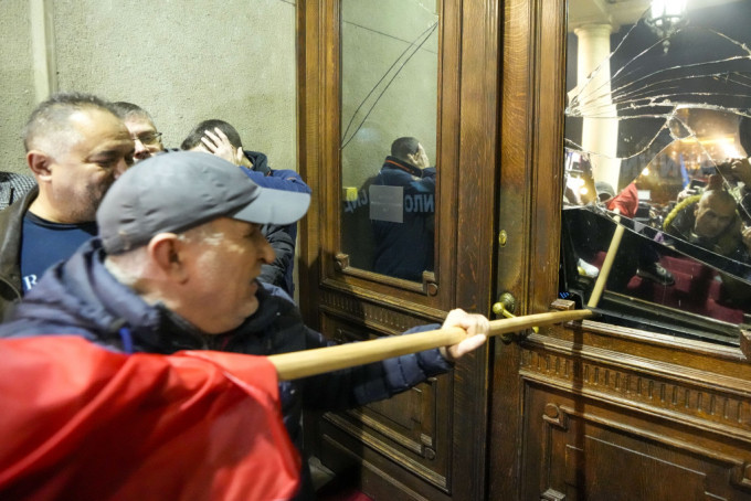 塞爾維亞反對派示威者衝擊首都貝爾格萊德市政府大樓，用長棍打破窗戶，企圖闖入。美聯社