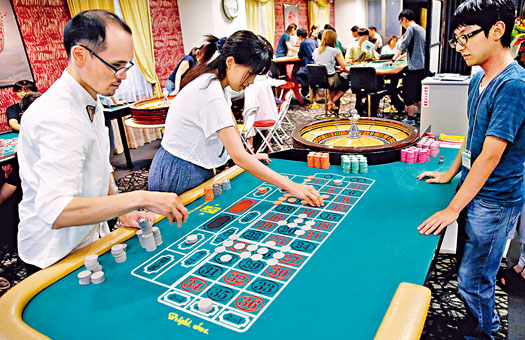 日本赌场学院的学生在练习操作轮盘赌桌。