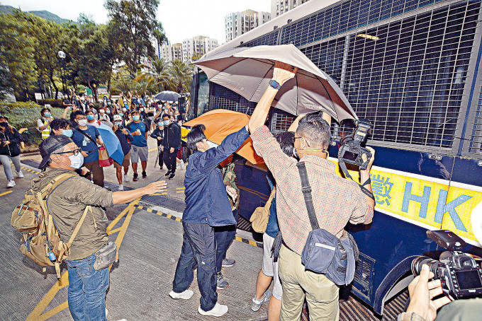 兩名被告由懲教署車輛押走時，聲援者以雨傘遮擋鏡頭。