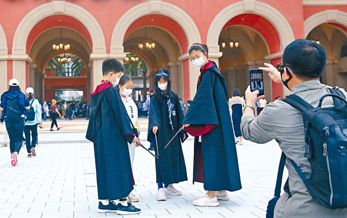 ■北京环球城市大道，小朋友身穿哈利波特主题服饰合影留念。
