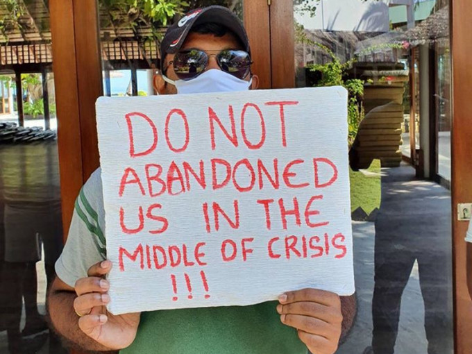 滯留馬爾代夫的中國員工，舉牌向外求救。(網圖)