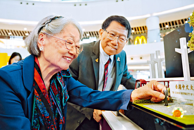 中大已故前校長高錕的妻子高黃美芸（左），親自把全人手製作的高錕微型雕像放進模型。旁為現任校長段崇智。