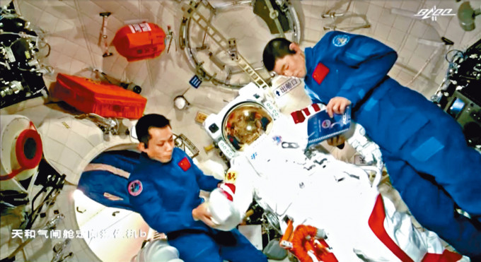 太空人在天和号核心舱内整理出舱太空服。　
