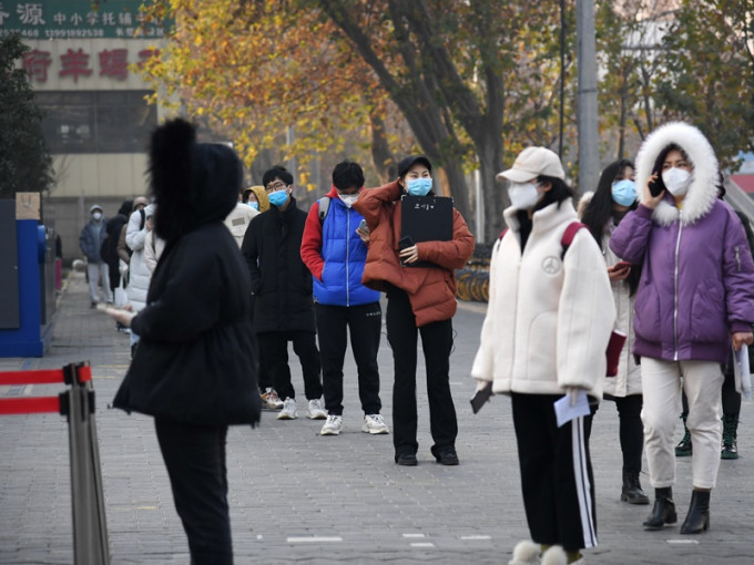 考生在西安市胡家廟地鐵站採樣點排隊接受核酸檢測。新華社