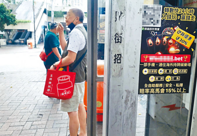 非法賭博集團派員到大埔廣場賽馬會投注站附近電話亭張貼宣傳單張，拉攏賭客參與非法賭博。