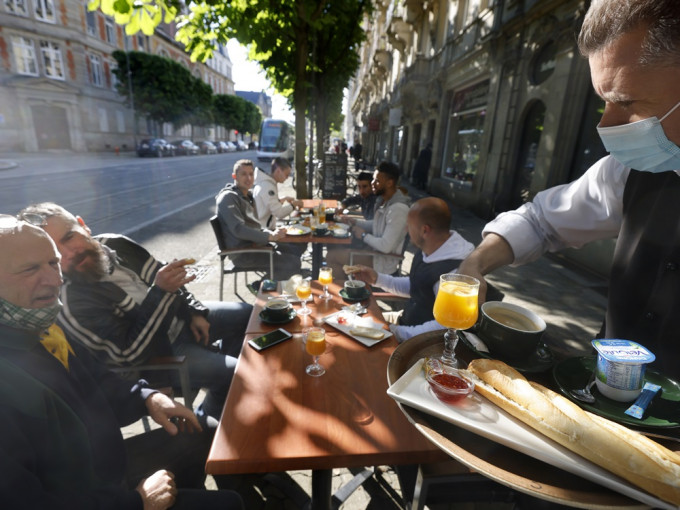 巴黎不少民众纷纷到咖啡馆和餐厅的露天座位上小聚。AP图片