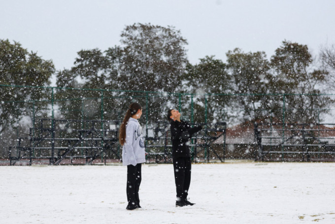 南非约翰内斯堡迎接2012年以来首场大雪，不少小朋友到公园玩雪。  路透社