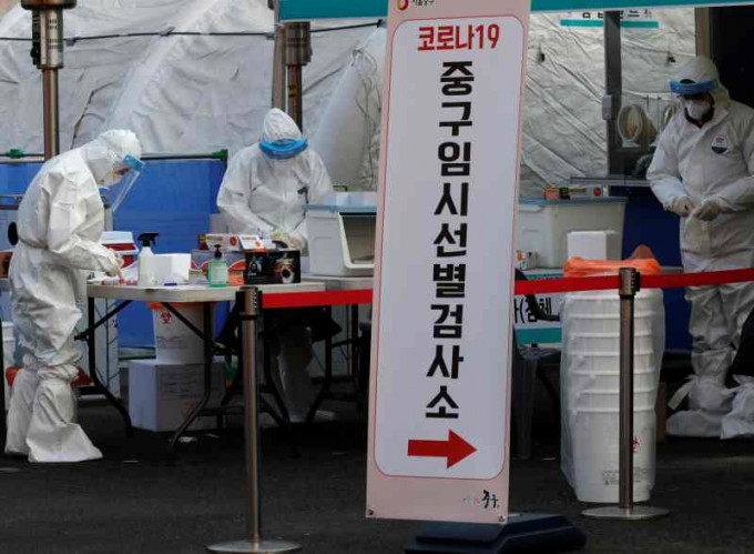医护人员全副防疫装备于首尔检测站工作。AP