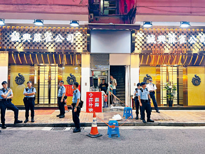 兩名藍帽子警員在荃灣河背街一麻將館門外，拘捕持刀男子。