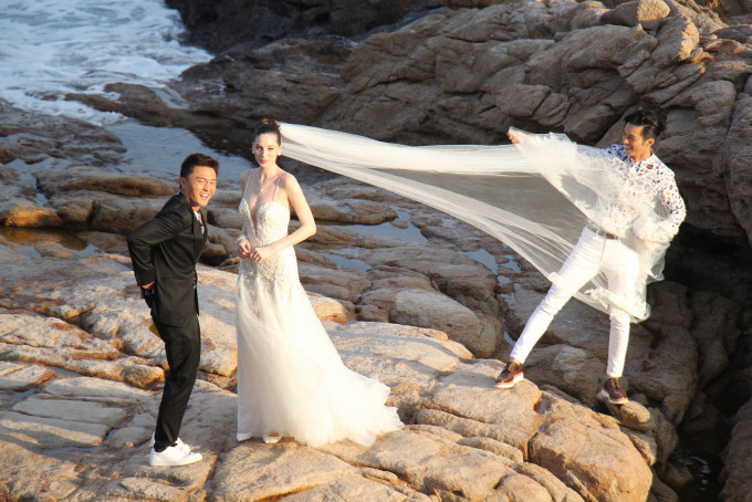 楊明與外籍女演員等在岸邊岩石上開工。