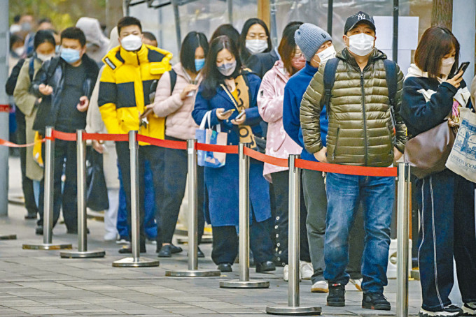 在北京戴口罩的市民於一個新冠病毒檢測點排隊接受核酸檢測。