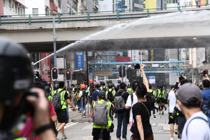 水炮车两度射水驱散人群。