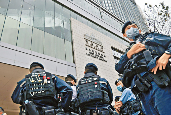 西九龍法院昨審立法會初選案，法院玻璃幕牆被射爆，大批警員到場戒備。