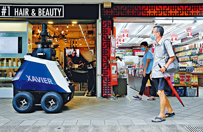 机械人周一在新加坡一个商场，监察市民的新冠违规行为。　