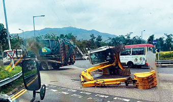 運送中挖泥車從拖架車上墮下翻側。