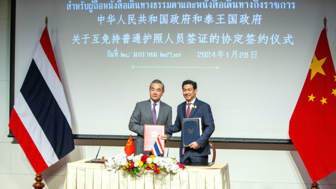 外交部長王毅在曼谷與泰國副總理兼外長班比簽署互免簽證協定。新華社