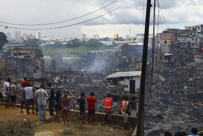 巴西贫民区大火烧毁逾600间木屋，居民纷纷逃离家园。AP
