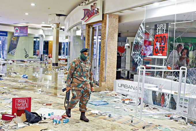 南非索韦托一个购物中心遭抢掠和破坏，军人昨检视损毁情况。