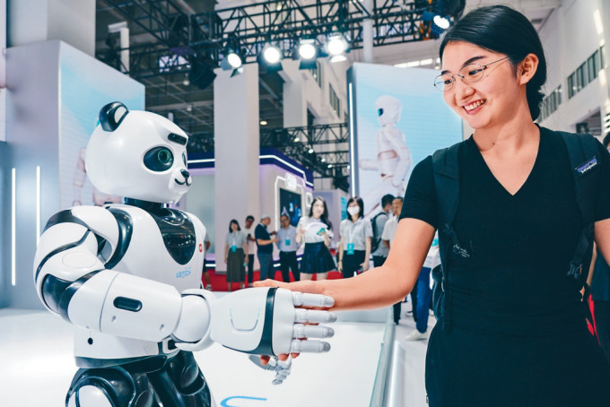 一名女士在北京與智能機器人握手。