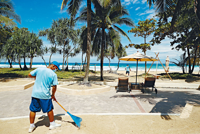 工人打扫布吉岛一处沙滩，准备七月一日起迎接旅客。