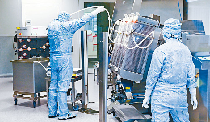 德国生物技术公司IDT Biologika人员操作制造疫苗机器。