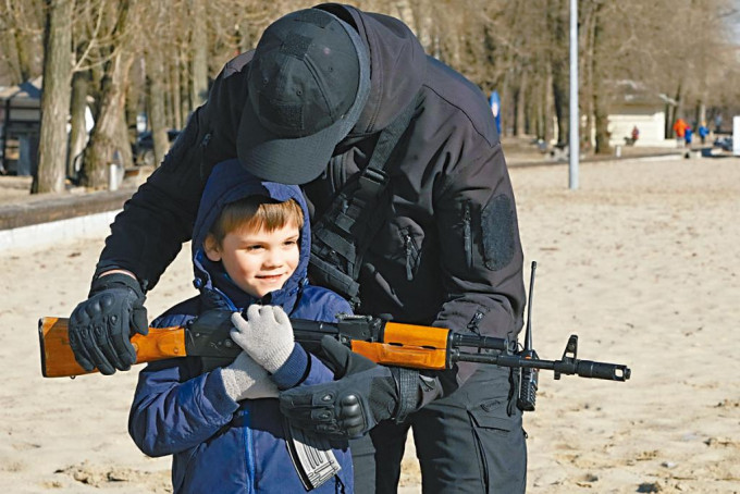 烏克蘭右翼組織成員周日在基輔的訓練中，協助男孩拿起AK-47自動步槍。  