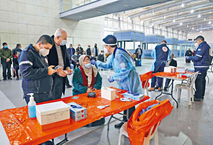 ■以色列接壤加沙地帶的埃雷茲邊境區，周一有醫護為準備入境的巴勒斯坦婦人做新冠肺炎檢測。