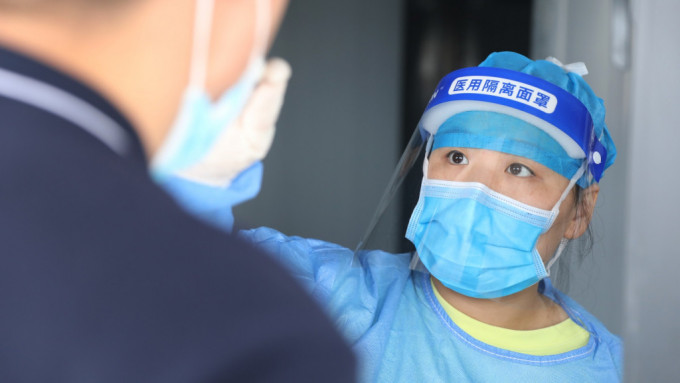 在河南省焦作市溫縣婦幼保健院核酸檢測點，醫務人員在為市民進行核酸採樣。 新華社圖片