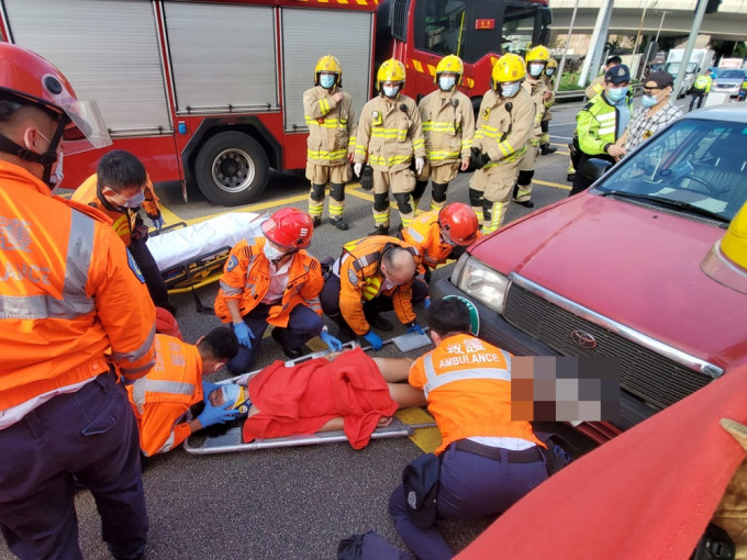 救护员将电单车司机抬上担架床送院。