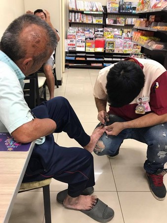台灣便利店一名店員，跪地替一名獨臂老伯剪腳趾甲。(網上圖片)