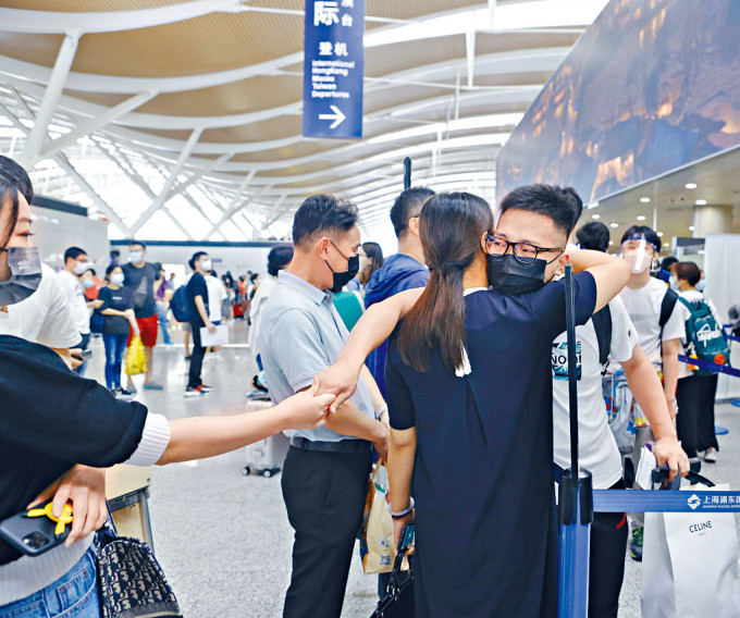 中国留学生重新踏上求学路。在上海浦东机场，留学生与亲人道别。